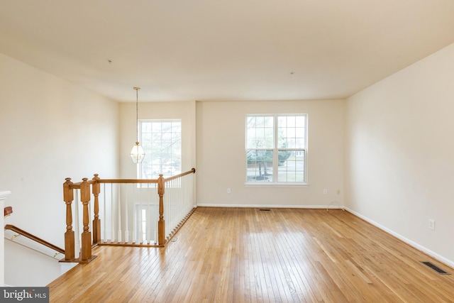 spare room featuring visible vents, baseboards, and light wood-style flooring