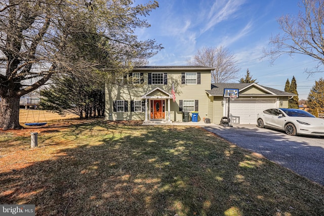 view of front of property featuring a garage, aphalt driveway, and a front yard