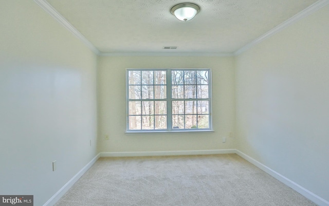 unfurnished room featuring carpet floors, visible vents, crown molding, and baseboards