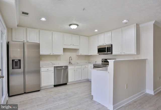 kitchen featuring appliances with stainless steel finishes, light wood-type flooring, light countertops, and white cabinetry