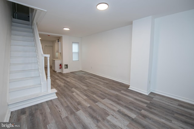 below grade area with stairway, baseboards, and wood finished floors