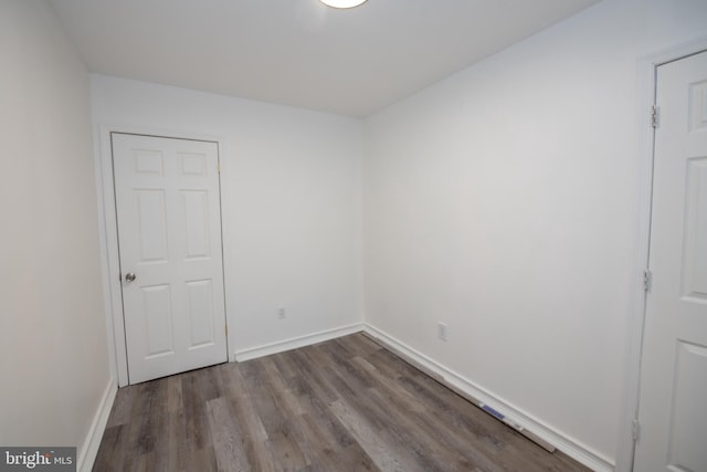 unfurnished room featuring baseboards and wood finished floors