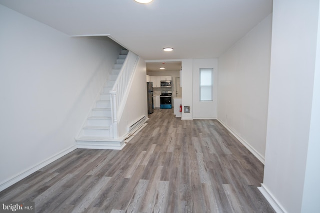 foyer with stairway, baseboards, and wood finished floors