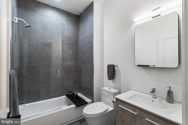 bathroom with toilet, bath / shower combo with glass door, and vanity