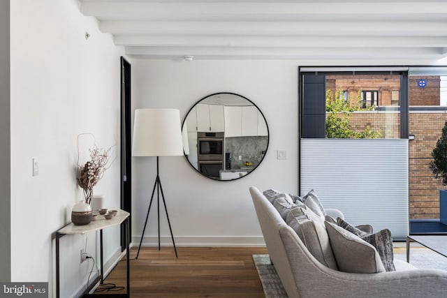 interior space featuring beamed ceiling, dark wood-style flooring, and baseboards