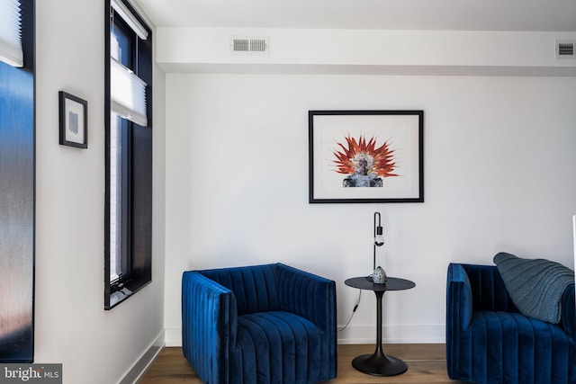 sitting room with baseboards, visible vents, and dark wood-type flooring