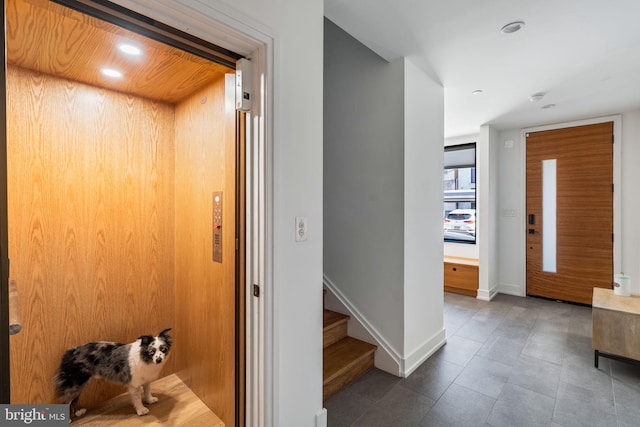 hallway featuring baseboards, elevator, stairway, tile patterned flooring, and recessed lighting