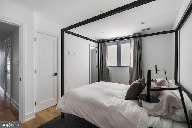 bedroom featuring wood finished floors and visible vents