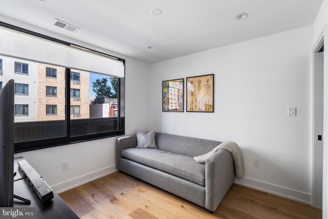 sitting room featuring wood finished floors, visible vents, and baseboards