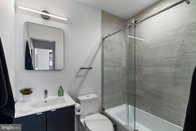 bathroom featuring vanity, a tile shower, and toilet