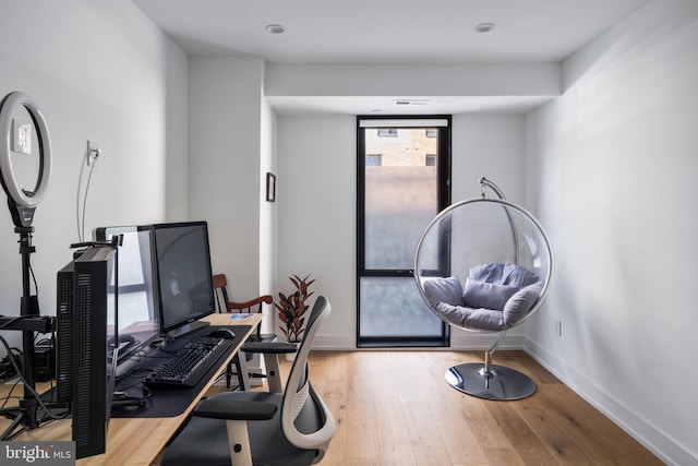 home office featuring visible vents, baseboards, and hardwood / wood-style floors