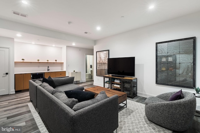 living area with baseboards, visible vents, light wood-type flooring, indoor wet bar, and recessed lighting