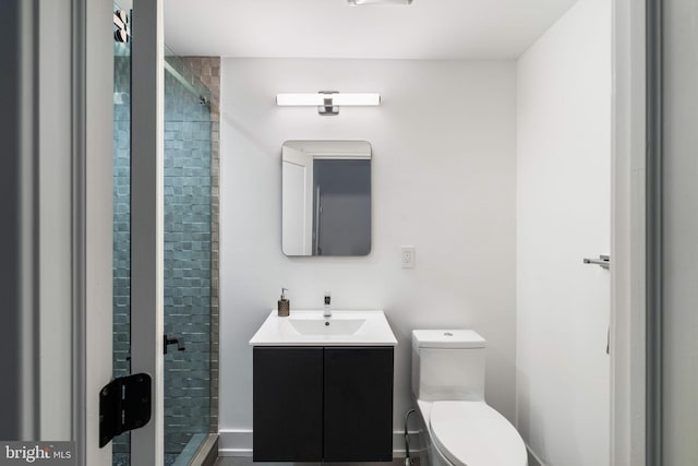 bathroom with toilet, a stall shower, and vanity