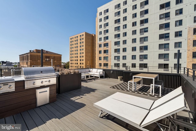 wooden terrace with an outdoor hangout area and area for grilling