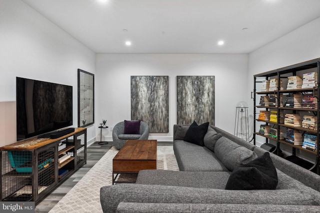 living area with baseboards, wood finished floors, and recessed lighting