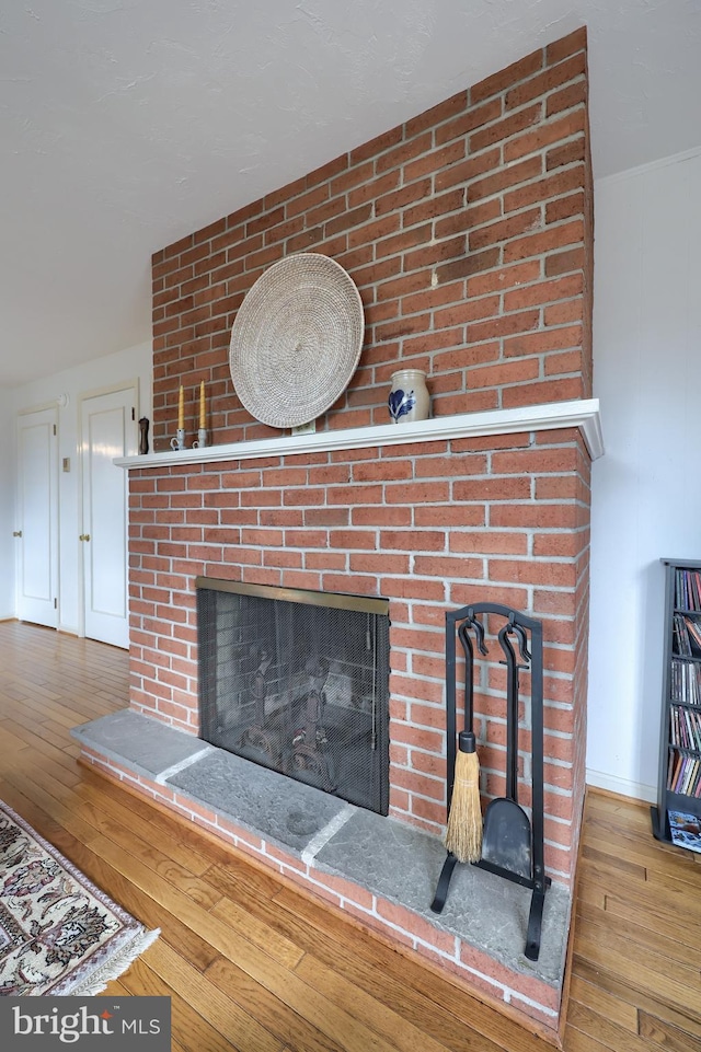 room details with a fireplace, wood finished floors, and baseboards