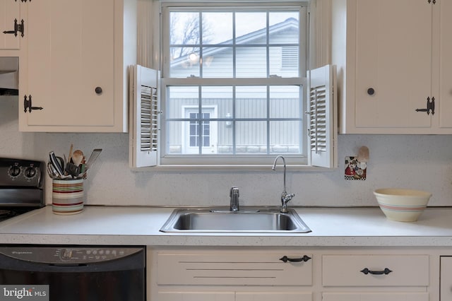 kitchen with a healthy amount of sunlight, black dishwasher, and white cabinets