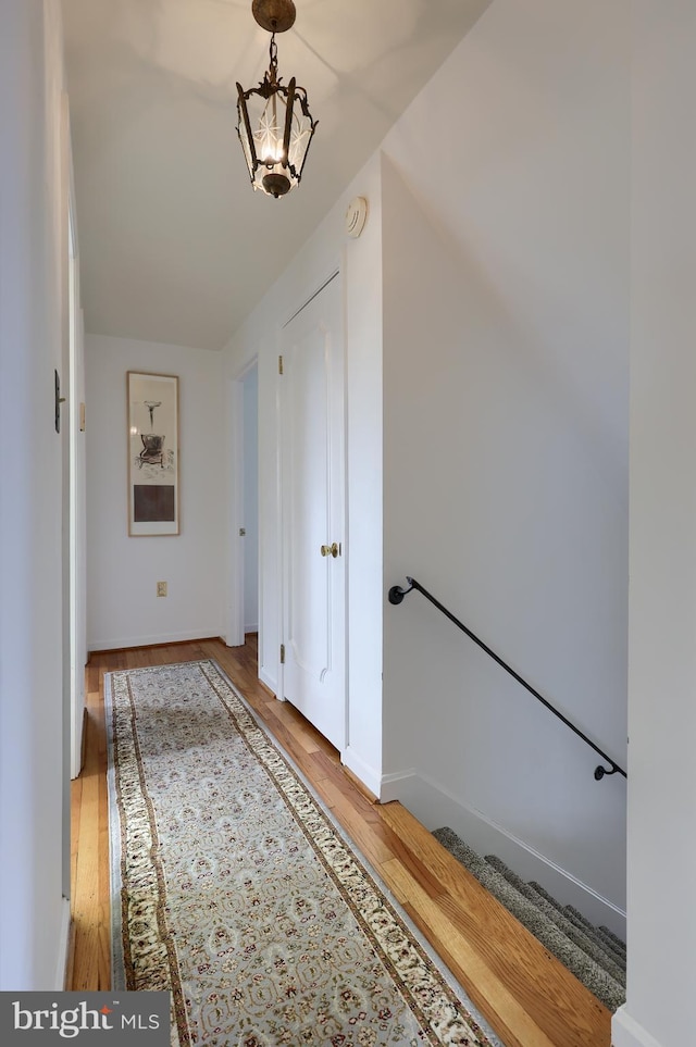 hall with light wood-style flooring and baseboards