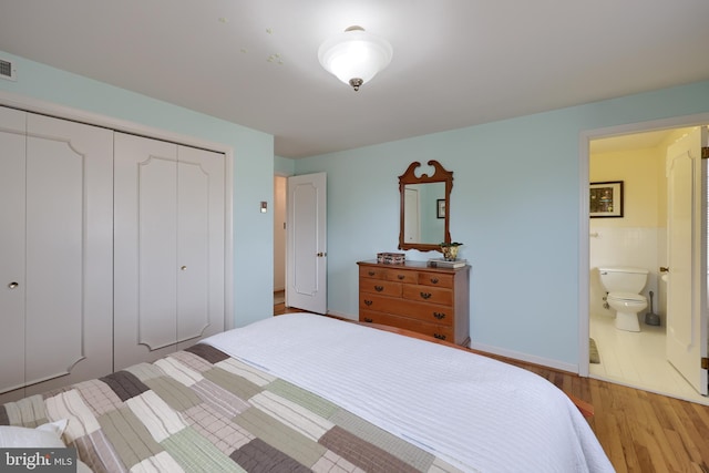 bedroom featuring a closet, connected bathroom, and light wood-style flooring