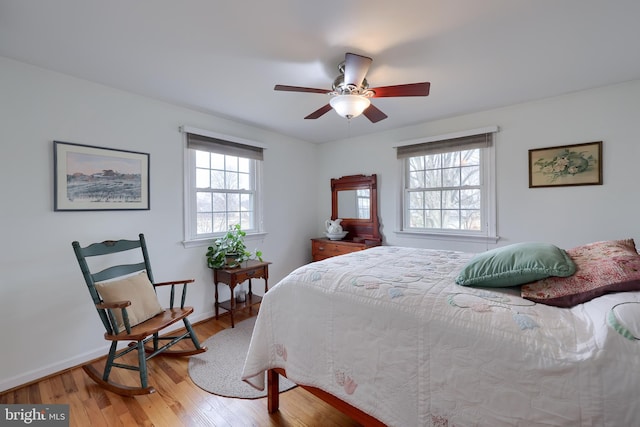 bedroom with wood finished floors, a ceiling fan, and baseboards