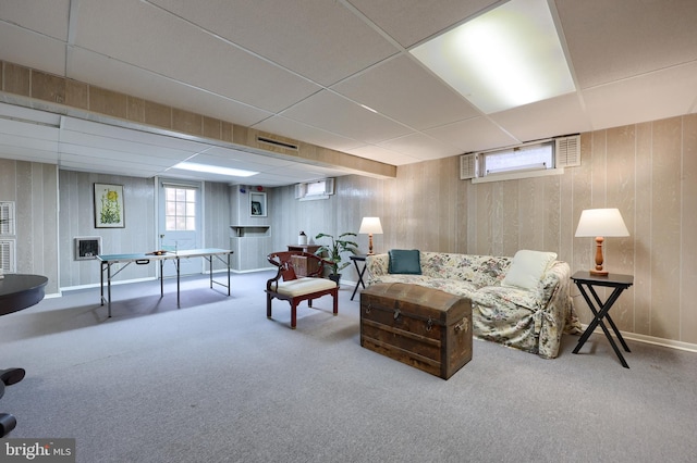 interior space with visible vents, an AC wall unit, wood walls, and a paneled ceiling