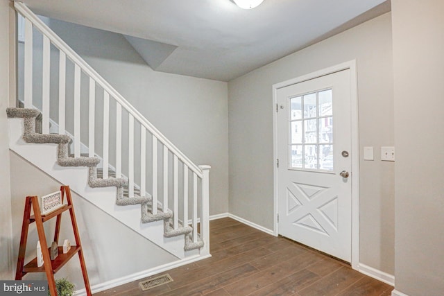 foyer entrance with stairway, wood finished floors, visible vents, and baseboards