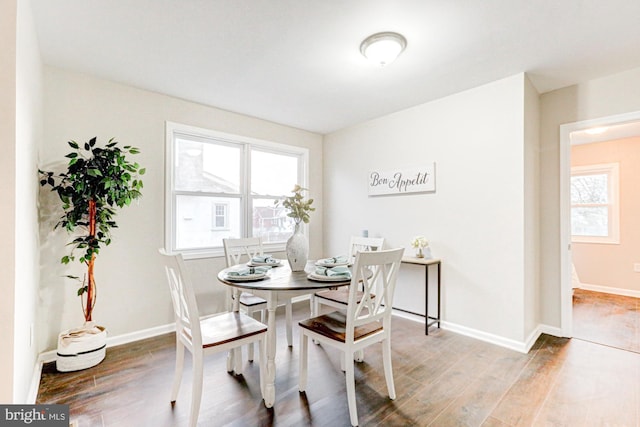 dining space featuring wood finished floors and baseboards