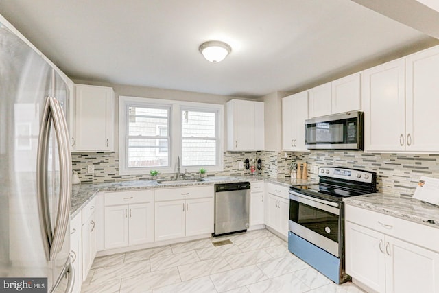 kitchen with marble finish floor, appliances with stainless steel finishes, white cabinets, and a sink