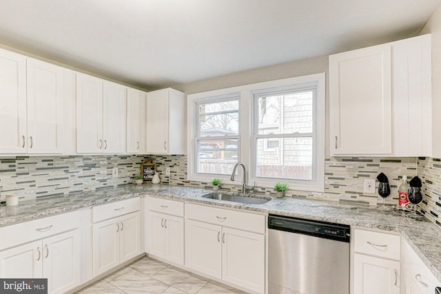 kitchen featuring tasteful backsplash, marble finish floor, a sink, and stainless steel dishwasher