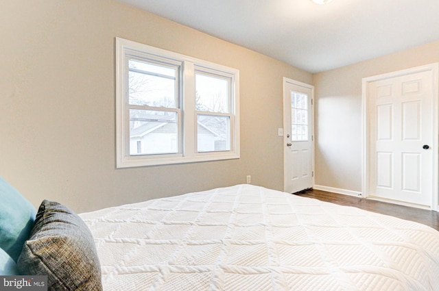 bedroom with dark wood-style floors and baseboards