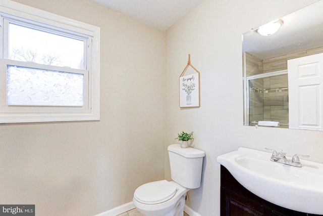 bathroom featuring a stall shower, baseboards, vanity, and toilet