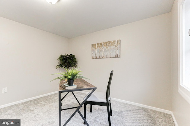 carpeted home office featuring baseboards