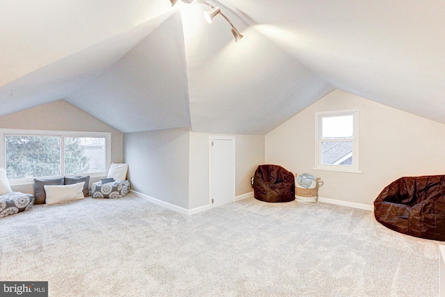 sitting room featuring carpet, baseboards, and vaulted ceiling