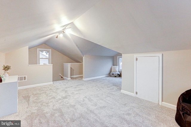 additional living space featuring vaulted ceiling, carpet, visible vents, and baseboards