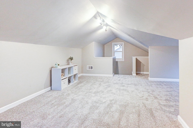 bonus room featuring lofted ceiling, carpet flooring, visible vents, and baseboards