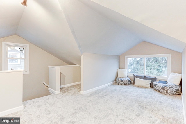 interior space featuring carpet floors, vaulted ceiling, and plenty of natural light