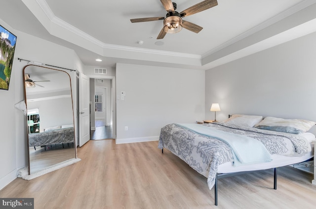 bedroom featuring ornamental molding, a raised ceiling, and visible vents