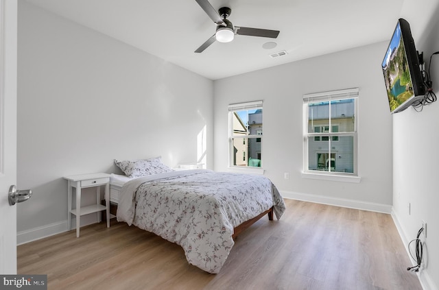 bedroom featuring visible vents, baseboards, and wood finished floors