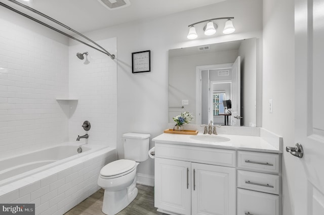 full bathroom featuring visible vents, toilet, wood finished floors, tub / shower combination, and vanity