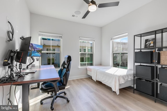 bedroom featuring light wood finished floors, a ceiling fan, visible vents, and baseboards