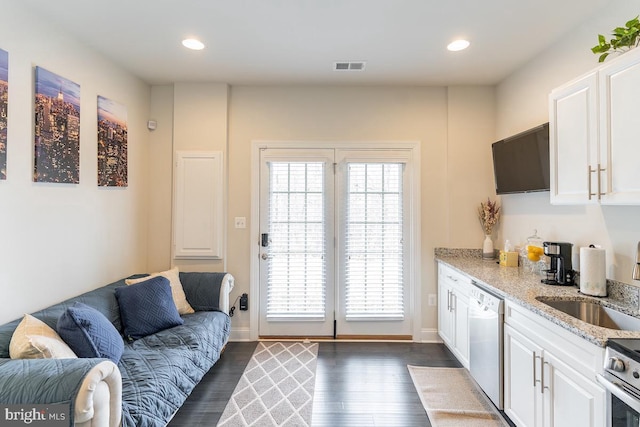 kitchen with visible vents, dishwasher, a sink, and white cabinetry