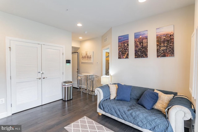 living room featuring dark wood-style floors, baseboards, visible vents, and recessed lighting