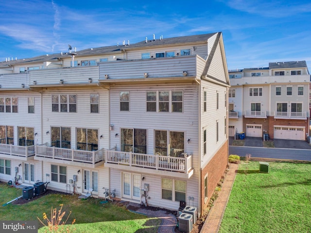 back of property with central AC unit and a lawn