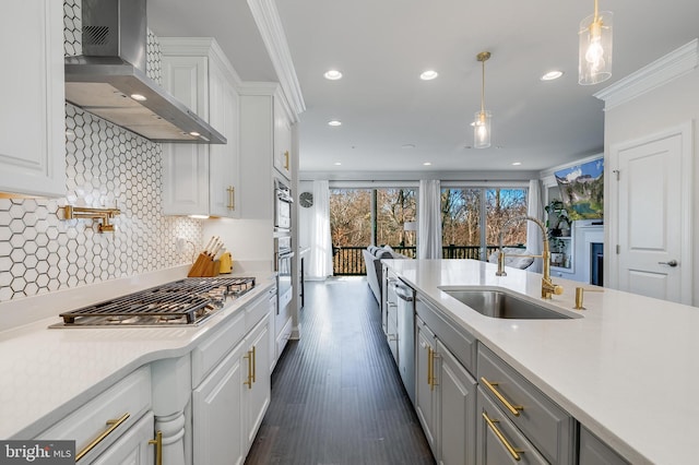 kitchen featuring stainless steel appliances, wall chimney range hood, light countertops, and white cabinets