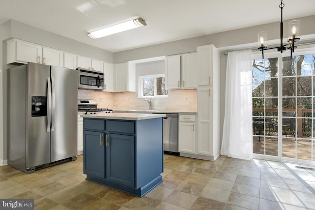 kitchen with decorative backsplash, white cabinetry, stainless steel appliances, and light countertops