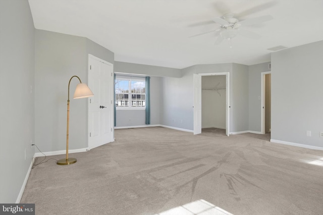 carpeted spare room with a ceiling fan, visible vents, and baseboards