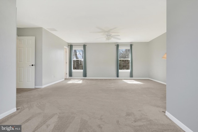 empty room with carpet floors, baseboards, and a wealth of natural light