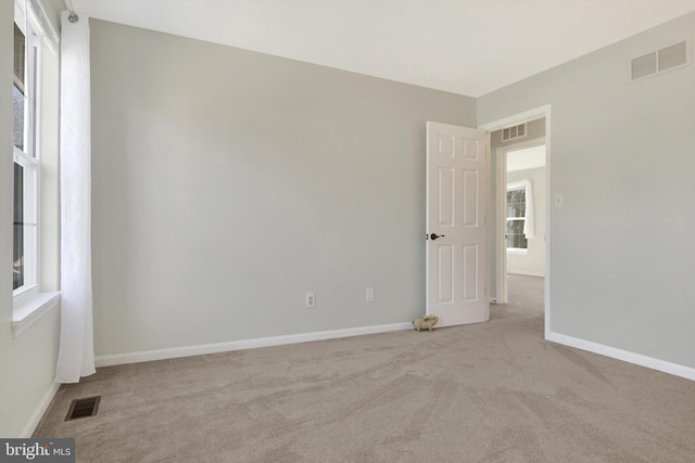 unfurnished room featuring baseboards, visible vents, and carpet flooring