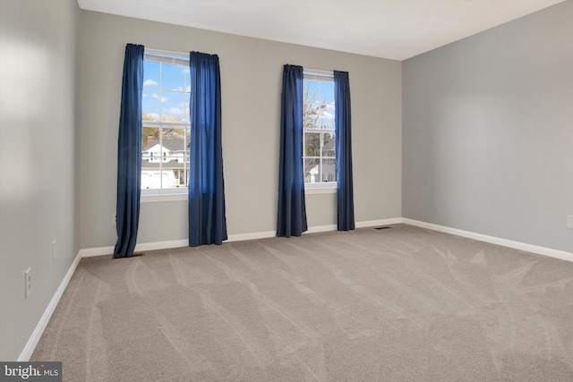 carpeted empty room with visible vents and baseboards