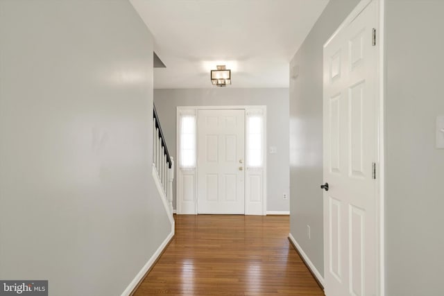 entryway with stairs, baseboards, and hardwood / wood-style floors